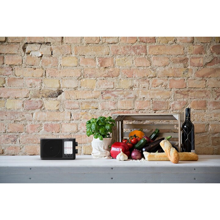 Radio AM/FM analógico portátil de Sony con mango de transporte incorporado, toma de auriculares y adaptador de CA
